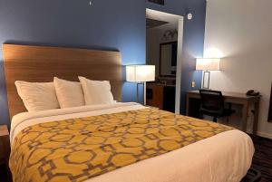 a hotel room with a large bed and a desk at Baymont by Wyndham Indianapolis Northwest in Indianapolis