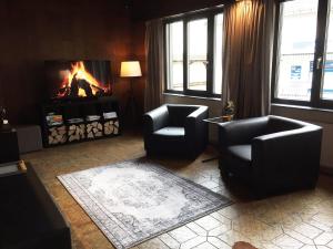 a living room with two chairs and a fireplace at Nice studio near Luxembourg in Bollendorf