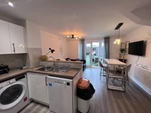a kitchen with a washing machine and a dining room at Luxury 10 Bed Palace w/ Parking in Birmingham