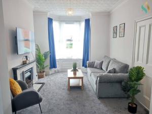 een woonkamer met een bank en een open haard bij St Bernard House TSAC in Stockton-on-Tees