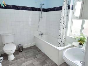 een badkamer met een bad, een toilet en een wastafel bij St Bernard House TSAC in Stockton-on-Tees +18 foto's