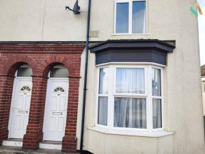 twee witte deuren aan de zijkant van een bakstenen gebouw bij St Bernard House TSAC in Stockton-on-Tees