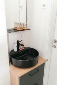 a bathroom with a black sink on a wooden counter at Pension Blumenwiese in Burgau