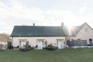 una casa con techo negro y patio de césped en Pension Blumenwiese, en Burgau