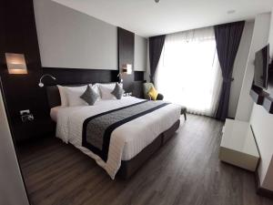 a bedroom with a large bed and a large window at SureStay Hotel by Best Western Vientiane in Vientiane