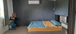 Dormitorio pequeño con cama y pared en โฮมสเตย์แม่ปราณี2, 