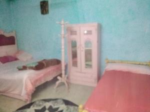 Habitación con cama y cruz en la pared en الشاكر للايجار, en Menia
