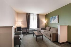 a living room with a couch and a table at SureStay Plus Hotel by Best Western SeaTac Airport in SeaTac