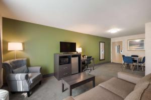 a living room with a couch and a tv at SureStay Plus Hotel by Best Western SeaTac Airport in SeaTac