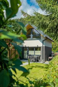 a small white house with a picnic table in a yard at Domek Tatary Odkryj Zakopane in Zakopane