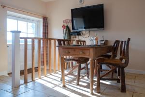 a room with a desk with chairs and a television at Pass the Keys Pheasant Cottage Stunning peaceful home parking in Moreton in Marsh