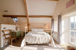 een slaapkamer met een bed, een bureau en een stoel bij Pass the Keys Pheasant Cottage Stunning peaceful home parking in Moreton in Marsh