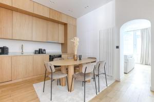 a kitchen with a wooden table and chairs at Zen & Luxury 2BR Flat - Eiffel Tower in Paris