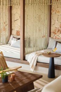 Sala de estar con 2 camas y mesa en Ikos Porto Petro, en Portopetro