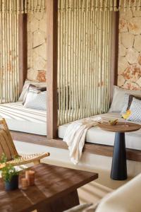 a living room with two beds and a table at Ikos Porto Petro in Portopetro