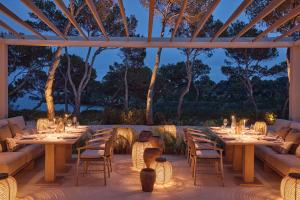a dining area with tables and chairs and lights at Ikos Porto Petro in Portopetro