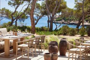 a patio with a table and chairs with a view of the ocean at Ikos Porto Petro in Portopetro