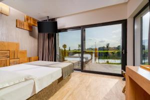 a bedroom with a bed and a large window at Serenity Resort in Codlea