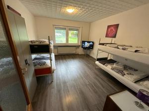 a room with two bunk beds and a television at Gästehaus Rachinger in Pappenheim