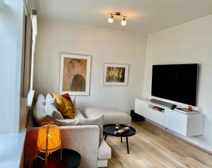 uma sala de estar com um sofá e uma televisão de ecrã plano em Cozy Central Hafnarfjörður - Reykjavík zone em Hafnarfjördur