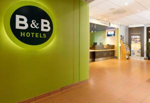 Un mur vert avec un panneau d'hôtels b b dans l'établissement B&B HOTEL Le Puy-en-Velay, à Vals-près-le-Puy