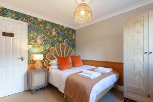 a bedroom with a bed with orange pillows at A gem nestled in the heart of Oxford with parking! in Oxford
