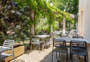 un patio al aire libre con mesas y sillas bajo una pérgola en B&B HOTEL Le Puy-en-Velay, en Vals-près-le-Puy