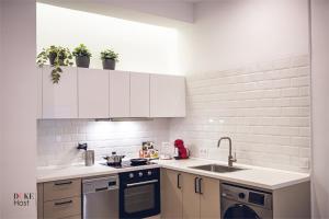 a kitchen with white cabinets and a sink at 5Torres Apartment in Madrid +13 photos