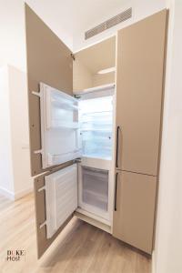 an empty refrigerator with its door open in a kitchen at 5Torres Apartment in Madrid