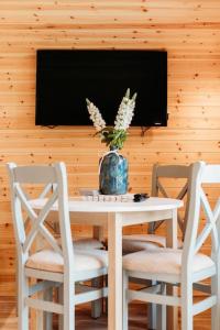 uma mesa com duas cadeiras e um vaso com flores em Riverside Retreats - Steamers Meadow em Gwinear