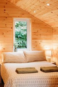 a bedroom with a large bed with a window at Riverside Retreats - Steamers Meadow in Gwinear