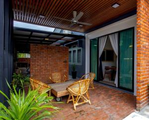 a patio with a table and chairs and a ceiling fan at Rumah Satu by NK in Alor Setar
