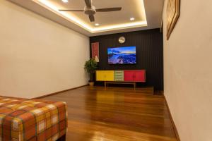 a living room with a couch and a tv on a wall at Rumah Satu by NK in Alor Setar