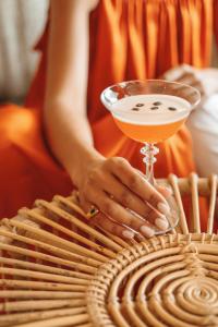 a woman holding a martini and a drink on top of a basket at Ikos Porto Petro in Portopetro