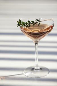 a martini glass with a rosemary garnishment at Ikos Porto Petro in Portopetro