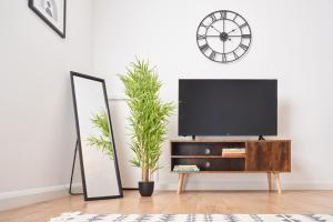 a living room with a tv and a mirror at 3 Bedroom Home in Central Milton Keynes in Loughton