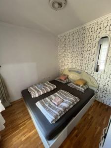 een slaapkamer met een bed met een zwart matras bij Jelena in Novi Sad