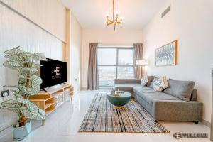 a living room with a couch and a tv at Lawnz-4 210 in Dubai