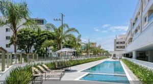 una piscina con tumbonas y un edificio en Apto Espetacular 180 m do mar, en Florianópolis