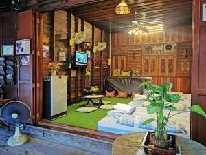 a living room with a couch and a table at Ban Mae Arom in Amphawa