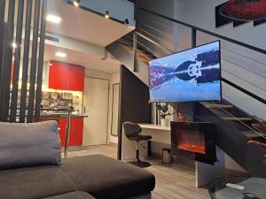a living room with a couch and a tv on a wall at Moraleja suite 2 in Alcobendas