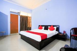 a bedroom with a large bed with red pillows at OYO Flagship 37109 Mangalam Guest House in Chinhat