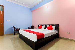 a bedroom with a bed with red pillows at OYO Flagship 37109 Mangalam Guest House in Chinhat