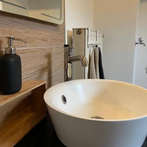 een badkamer met een witte wastafel en een zeepdispenser bij Ferienwohnung Mahar in Feistritz im Rosental
