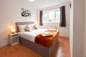 a bedroom with a bed with two towels on it at 3 Bedroom Home in Central Milton Keynes in Loughton