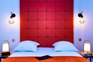 a red padded headboard in a bedroom with two lamps at Le Green des Impressionnistes in Ennery