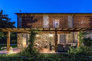 a stone house with a pergola at night at Villa Sul Fiume Romantic Farmhouse with Pool in Lucca