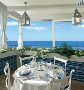 een eetkamer met een tafel en uitzicht op de oceaan bij Hotel Maremonti in Gabicce Mare