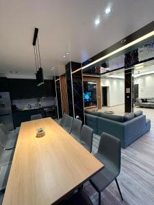 a dining room with a table and a couch at Villa Shefit in Rrushkull