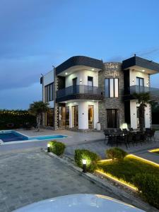 a villa with a swimming pool at dusk at Villa Shefit in Rrushkull